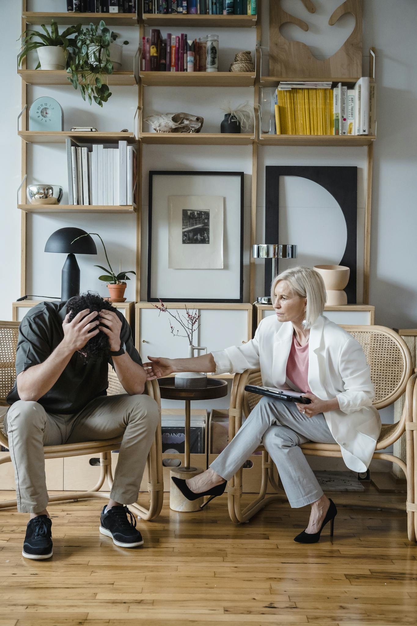 A therapist comforts a distressed client during a therapy session, symbolizing empathy and support.