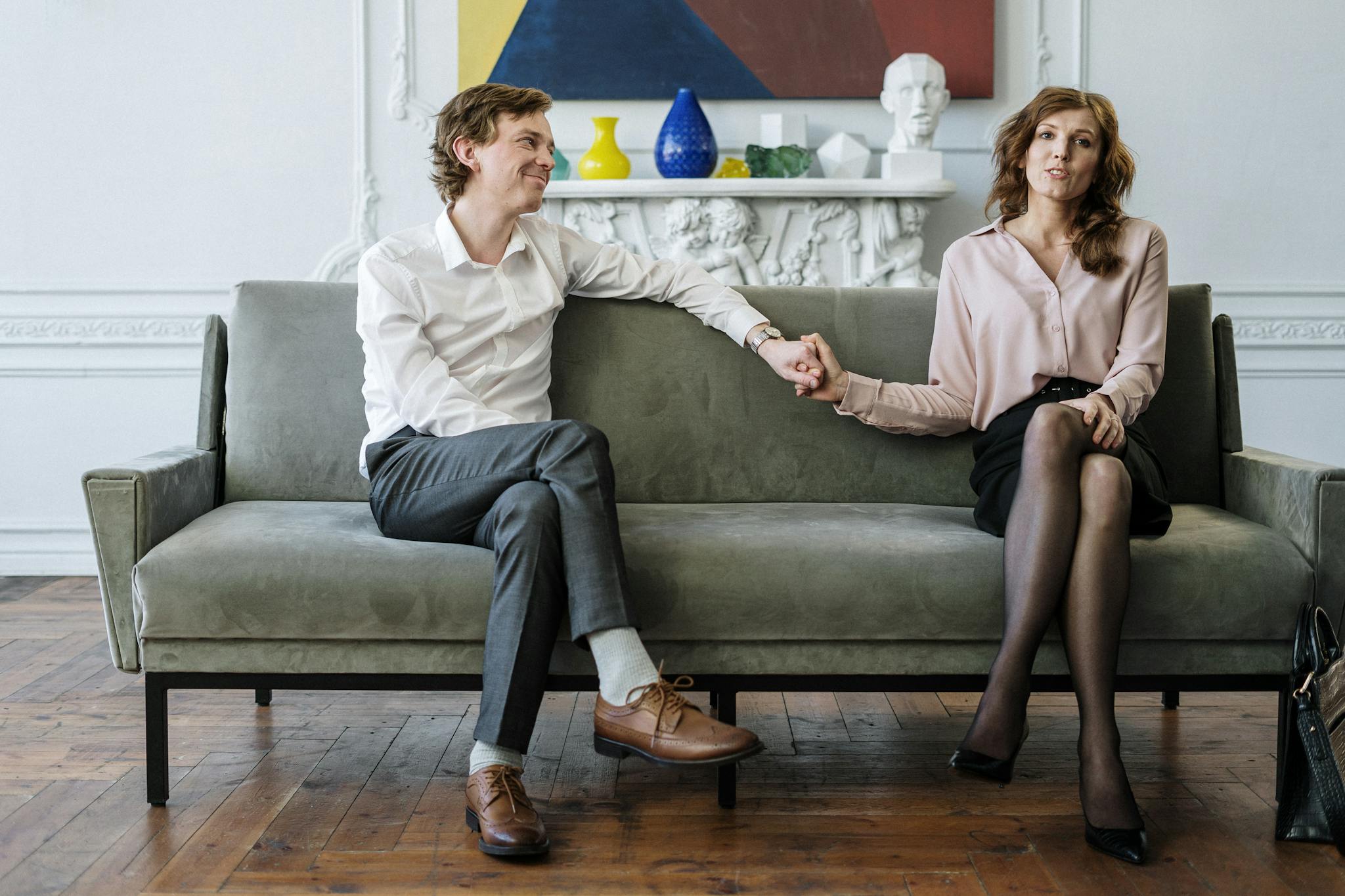 A couple in a therapy session holding hands, conveying support and connection.