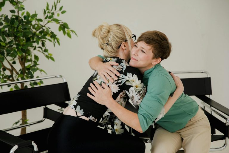Two women sharing a comforting hug in a therapy session, symbolizing trust and support.